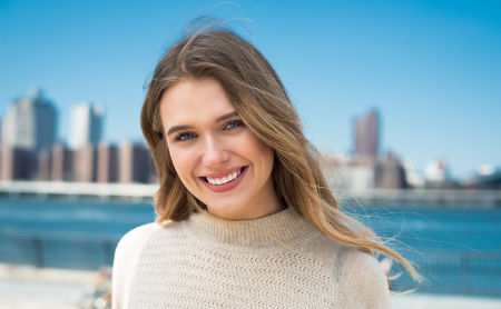 beautiful young woman with perfect natural white teeth smile at sunny day